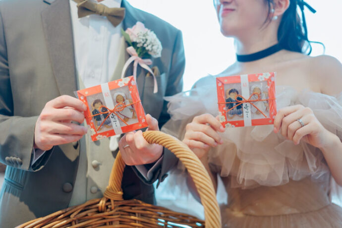 ゲストへのプチギフトを持つ新郎新婦