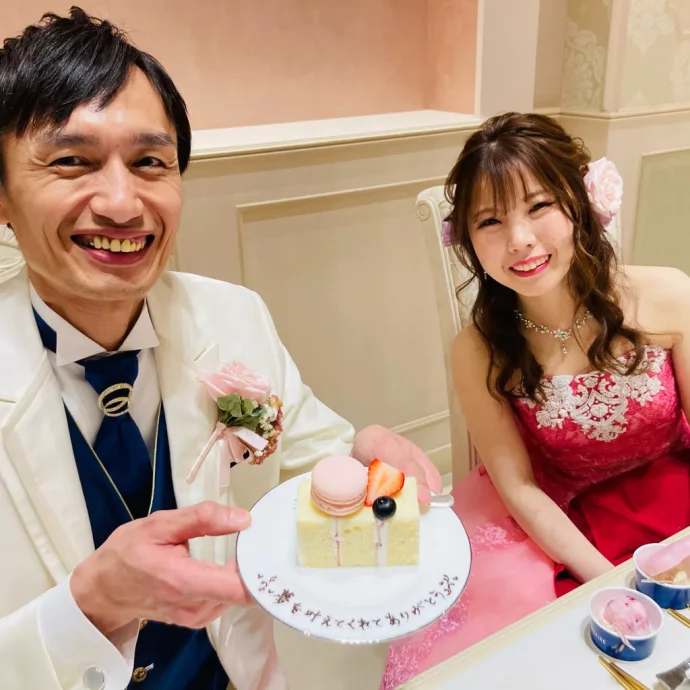 ウェディングにてデザートプレートと写真を撮る新郎新婦