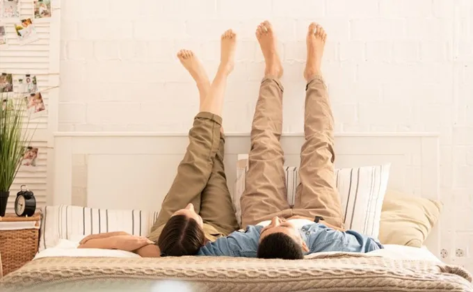 ベッドで足を上げるカップル