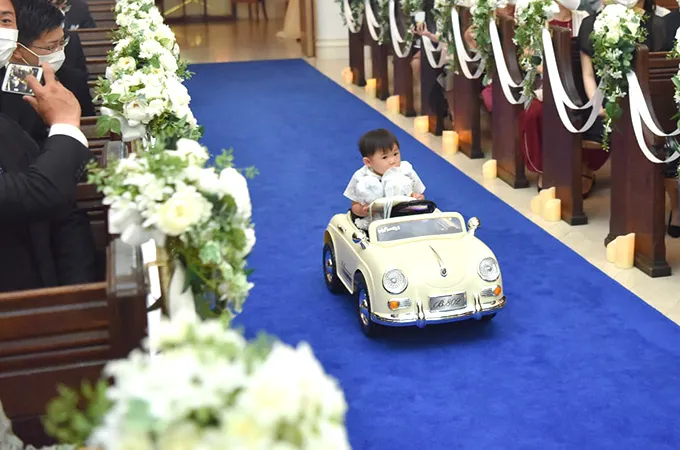 子供がおもちゃの車に乗って登場