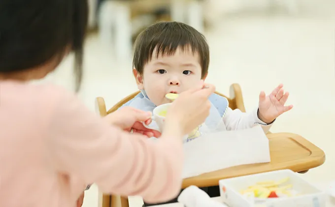 ママに食べさせてもらう赤ちゃん