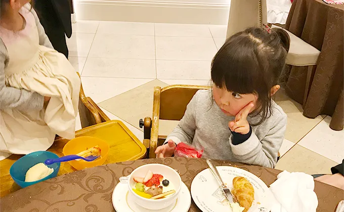 料理を前にピースする子供