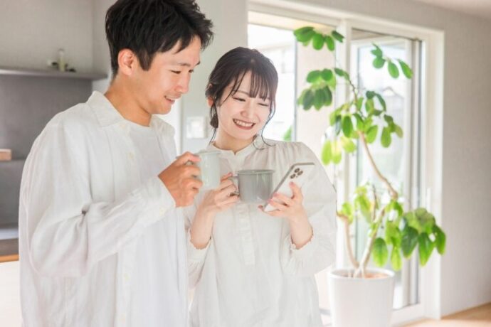一緒にスマートフォンを見る夫婦