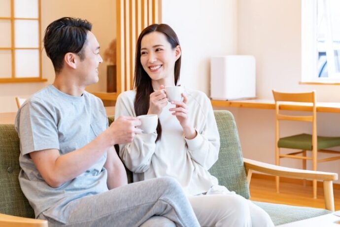リビングのソファーに座り会話する夫婦
