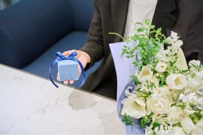 花束と婚約指輪でプロポーズの準備をする男性の手元