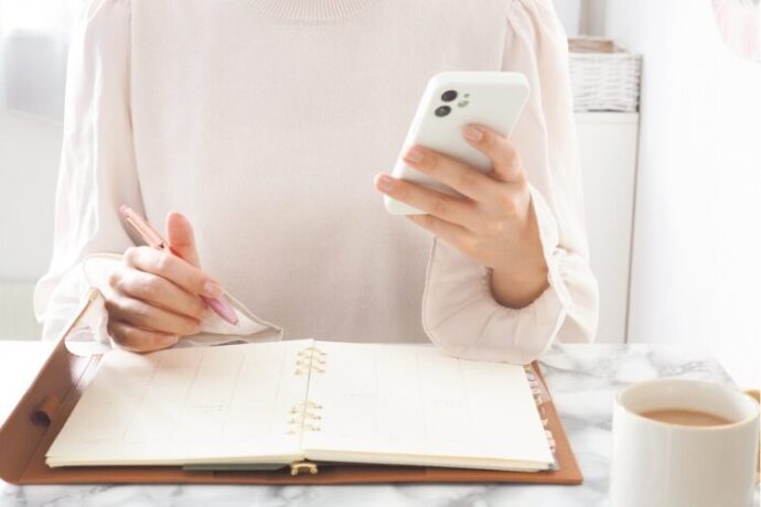 スケジュールに書き込む女性の手元