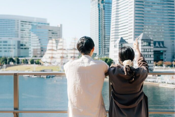 外の景色を見ながら話し合う男女の後ろ姿