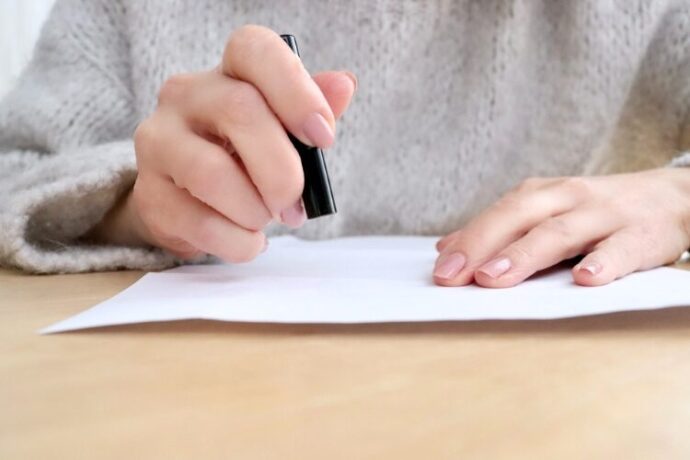 手続き書類に印鑑を押す女性の手元