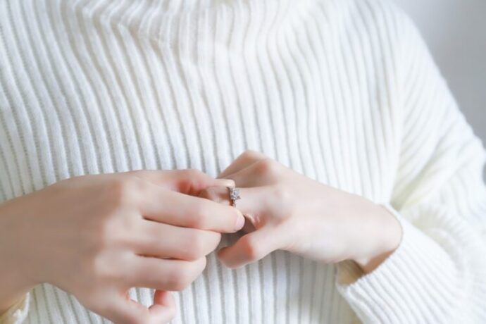 婚約指輪を外す女性の手元