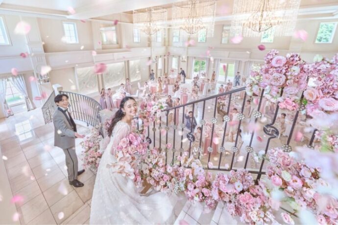 アニヴェルセルの披露宴会場の階段で微笑む新郎新婦