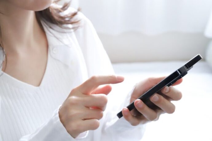 スマホでメッセージを送る女性の手元