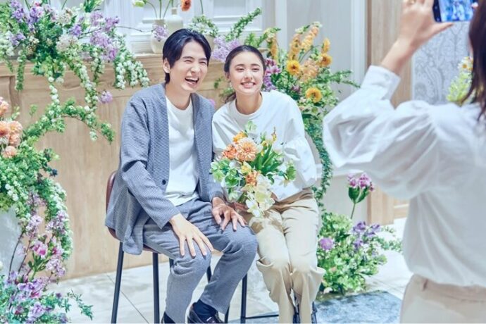 チェアスタイルの披露宴会場で記念写真をするカップル
