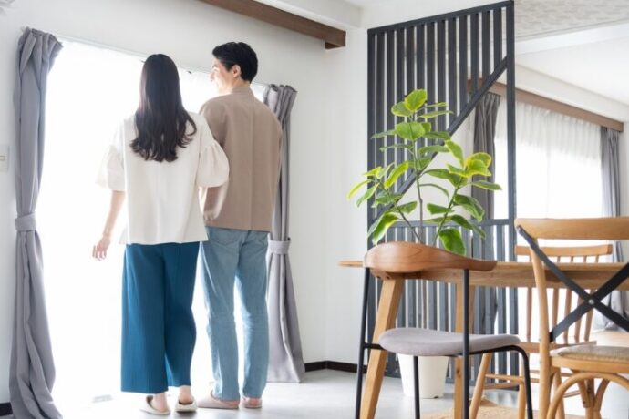 リビングで寄り添う夫婦の後ろ姿