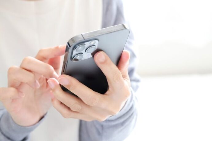 スマートフォンでメッセージを送る手元